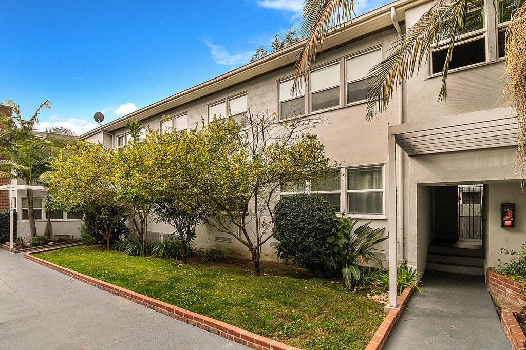 an apartment building with a yard in front of it