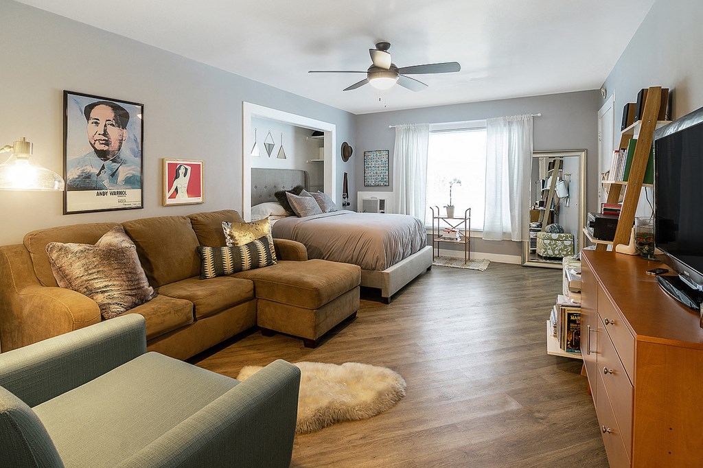 the living room and bedroom of a studio apartment