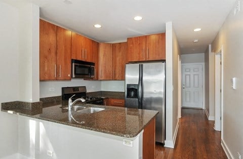 a kitchen with a granite counter top and a stainless steel refrigerator