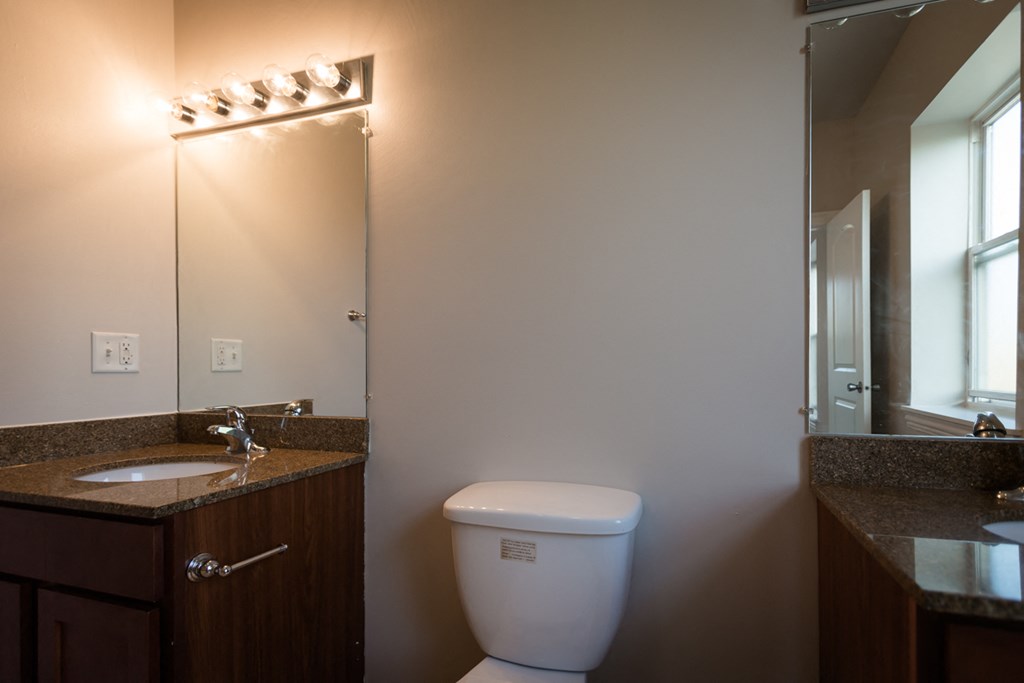 a bathroom with a toilet and a sink and a mirror