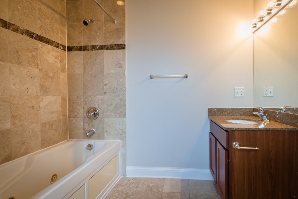 a bathroom with a tub and a sink and a mirror