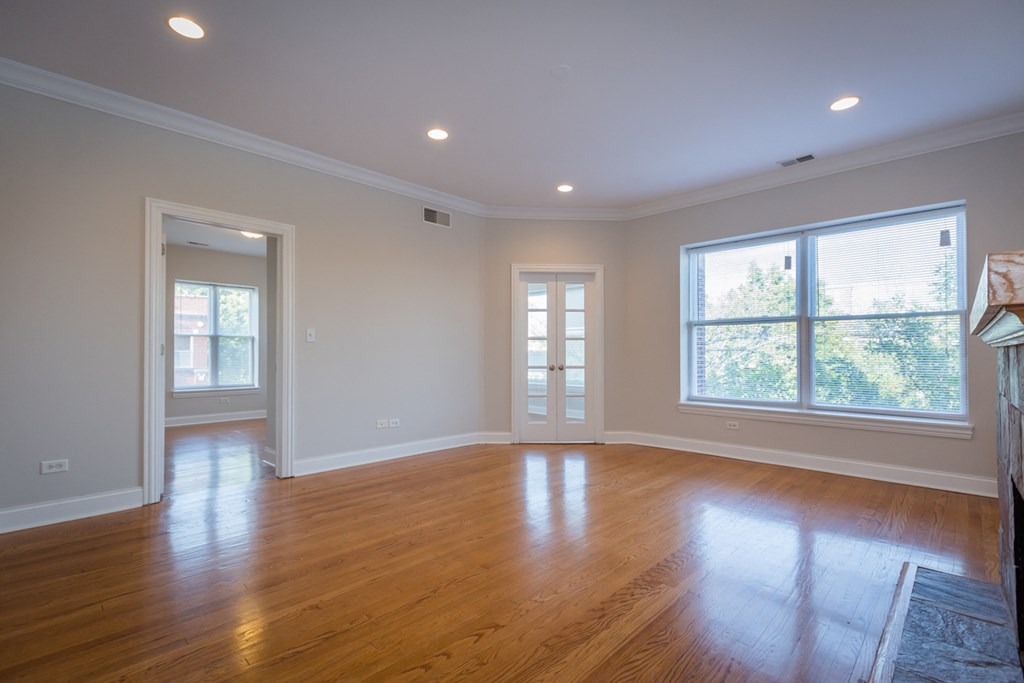 an empty living room with wood floors and windows