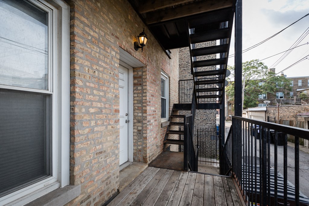 the exterior of a brick house with a stairway leading up to a door