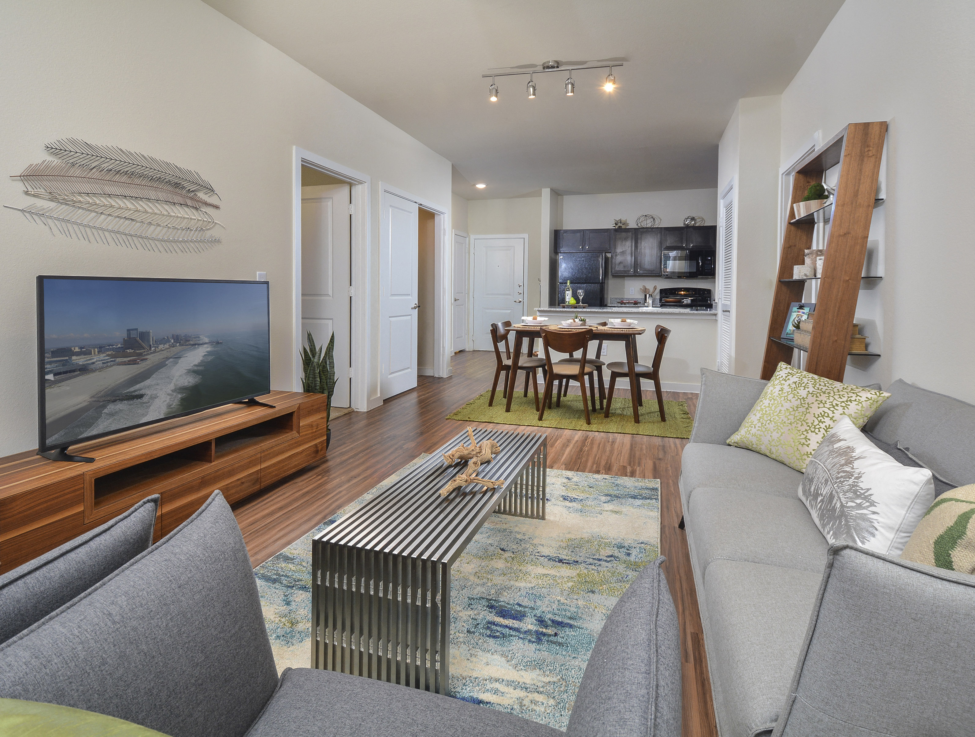 A living room with a grey couch and a wooden entertainment center.