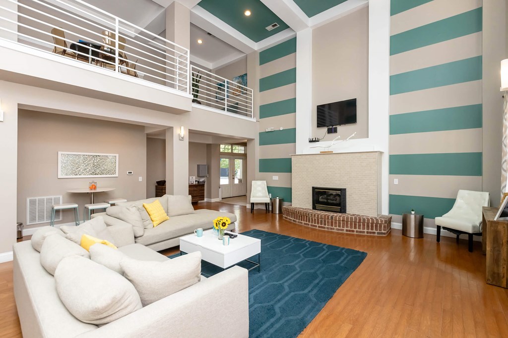 A living room with a white couch and a fireplace.