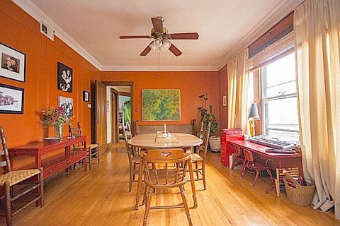 A dining room with a table surrounded by chairs.