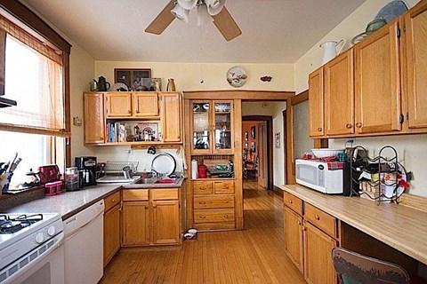 A kitchen with wooden cabinets and a stove top oven.