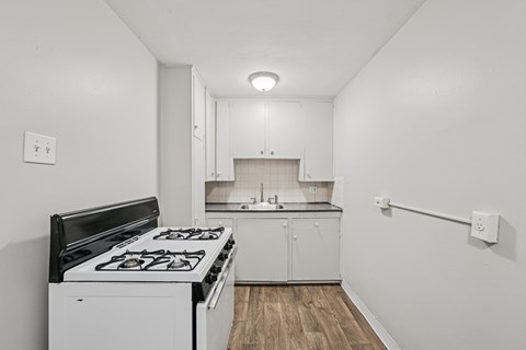 A white kitchen with a black stove top.