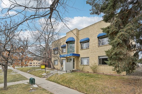 A building with a blue awning and a yellow sign on the front.