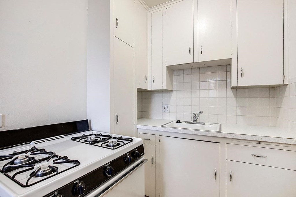 a white kitchen with a stove and a sink