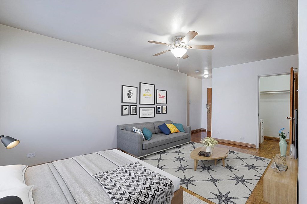 a bedroom with a couch and a ceiling fan