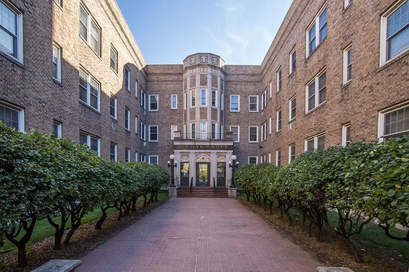 a large brick building with a courtyard and trees