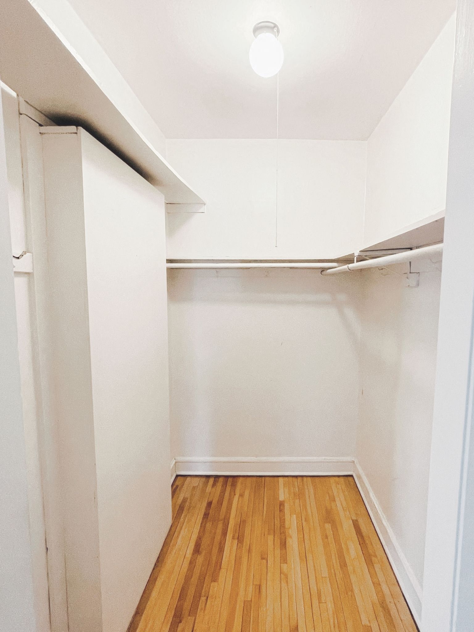 an empty room with white walls and a wood floor