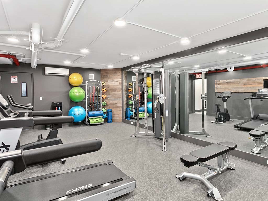 a gym with weights and other equipment on the floor