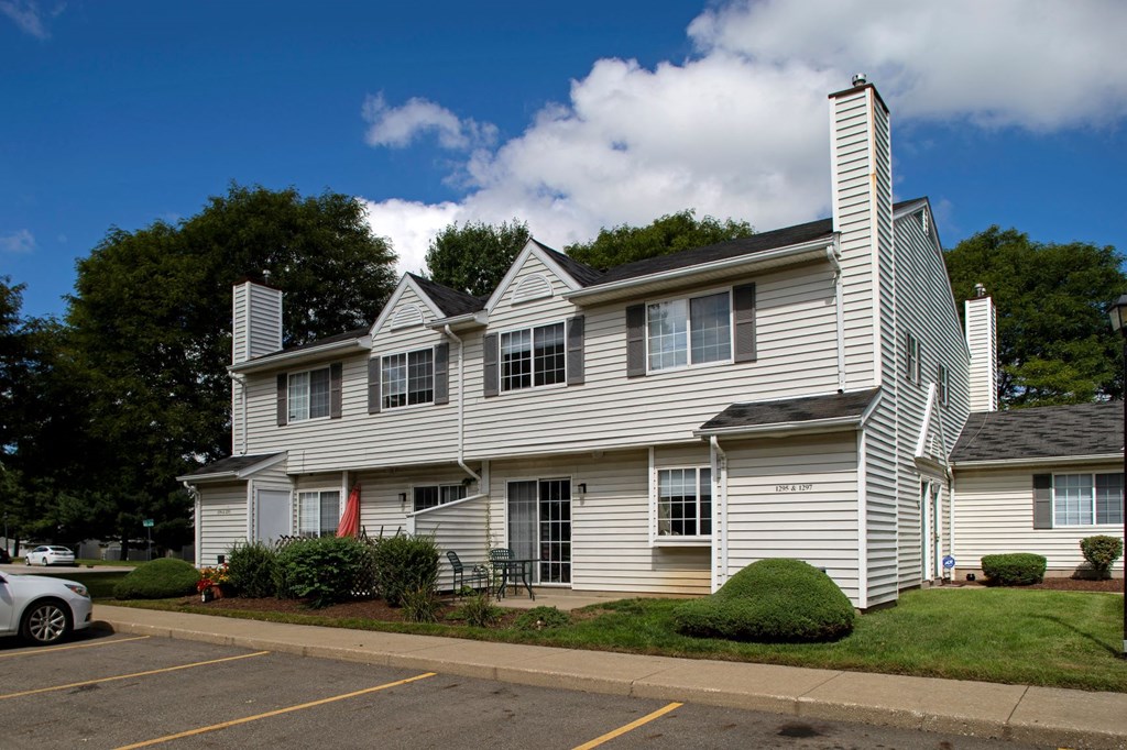 a white house with white siding in a parking lot