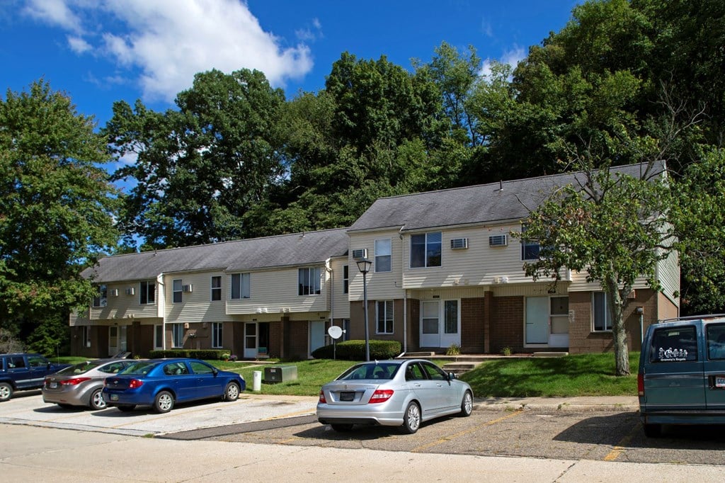 an apartment building with cars parked in front of it