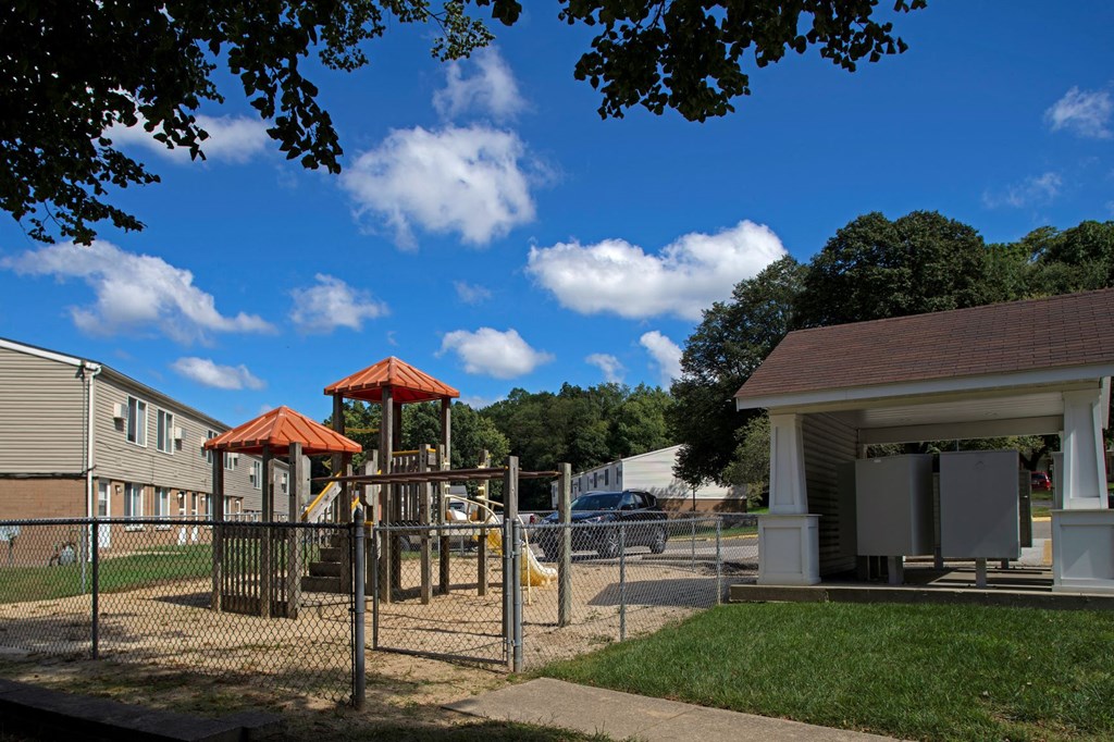 a playground with a swing set in front of a building