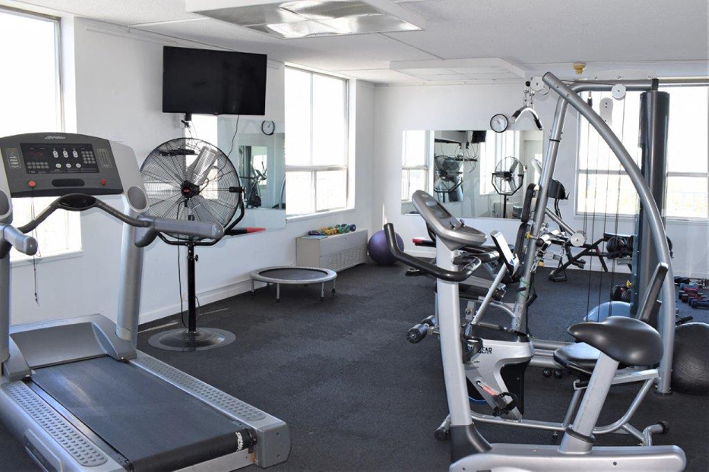 a gym with equipment and a tv in a room