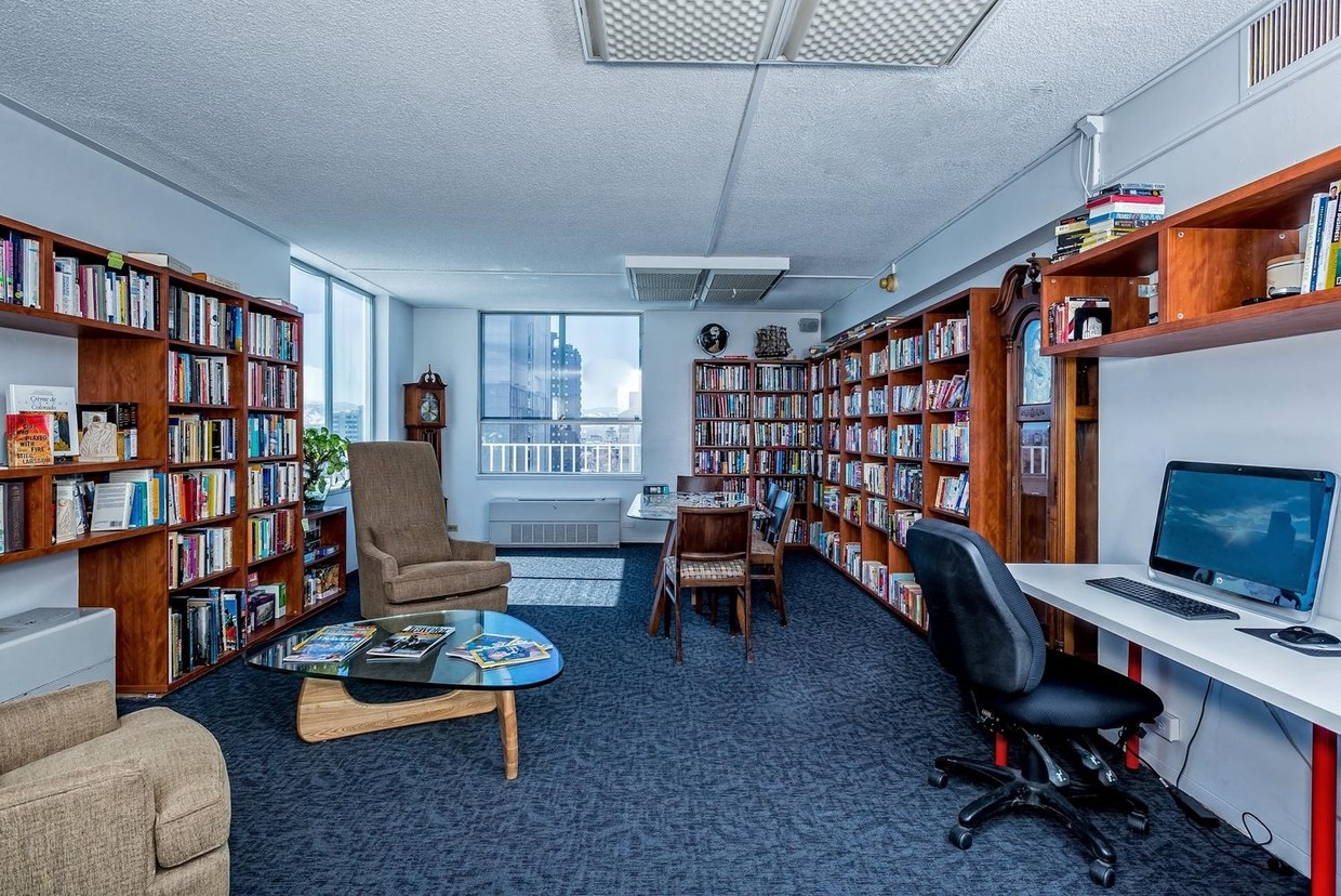 a library with bookshelves and a desk with a computer
