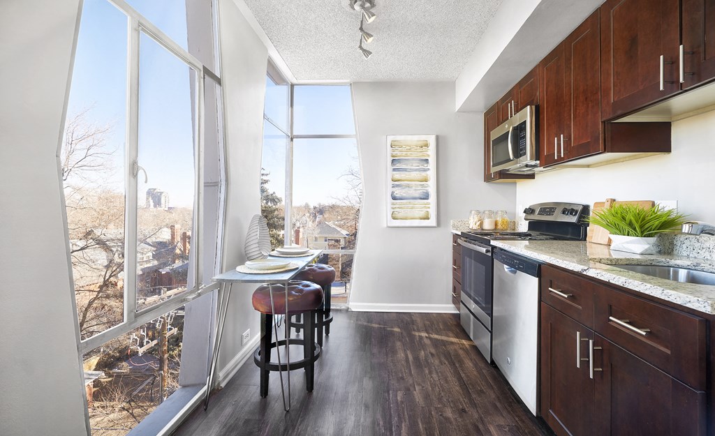 a kitchen with a large window and a table with two stools