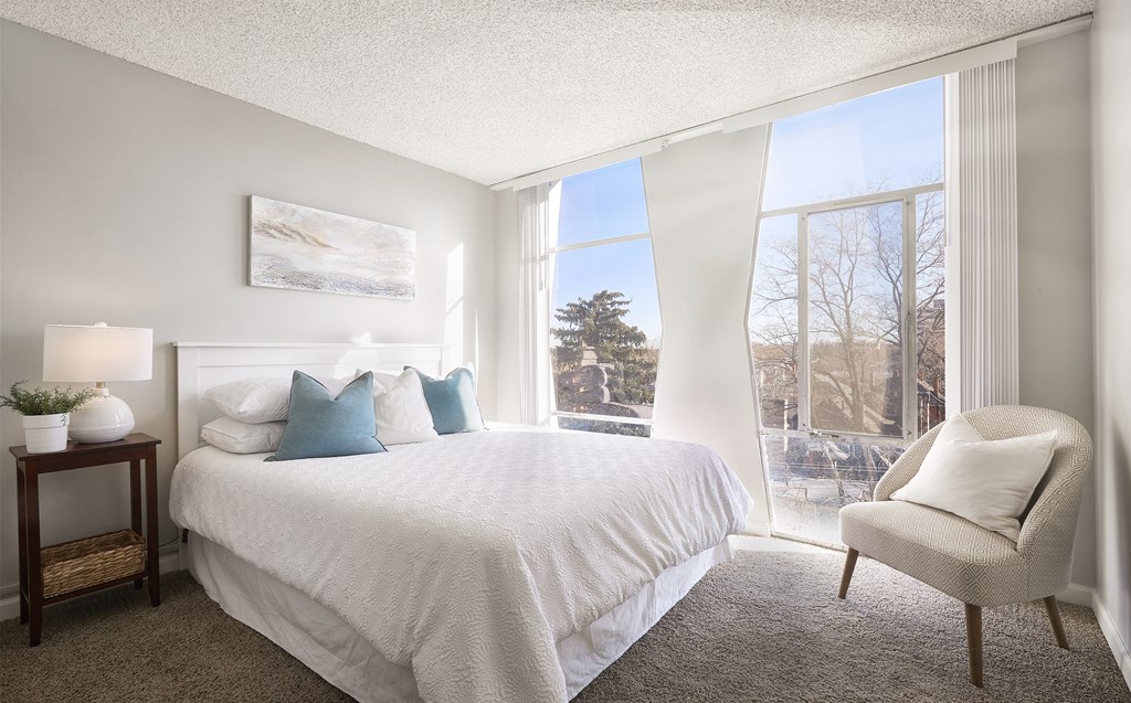 a bedroom with a bed and a large window