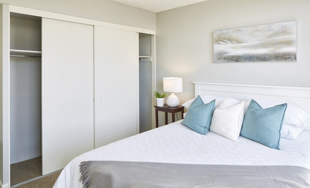 a bedroom with a bed with blue and white pillows