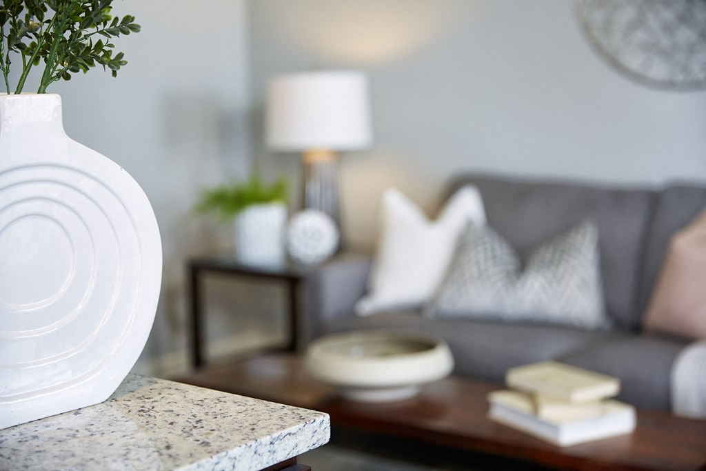 a living room with a white vase and a couch