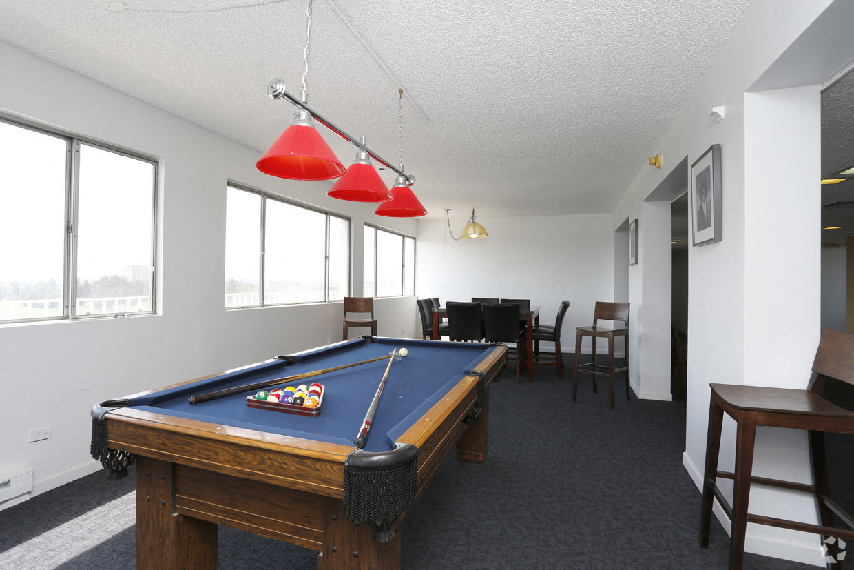 a living room with a pool table and a dining room