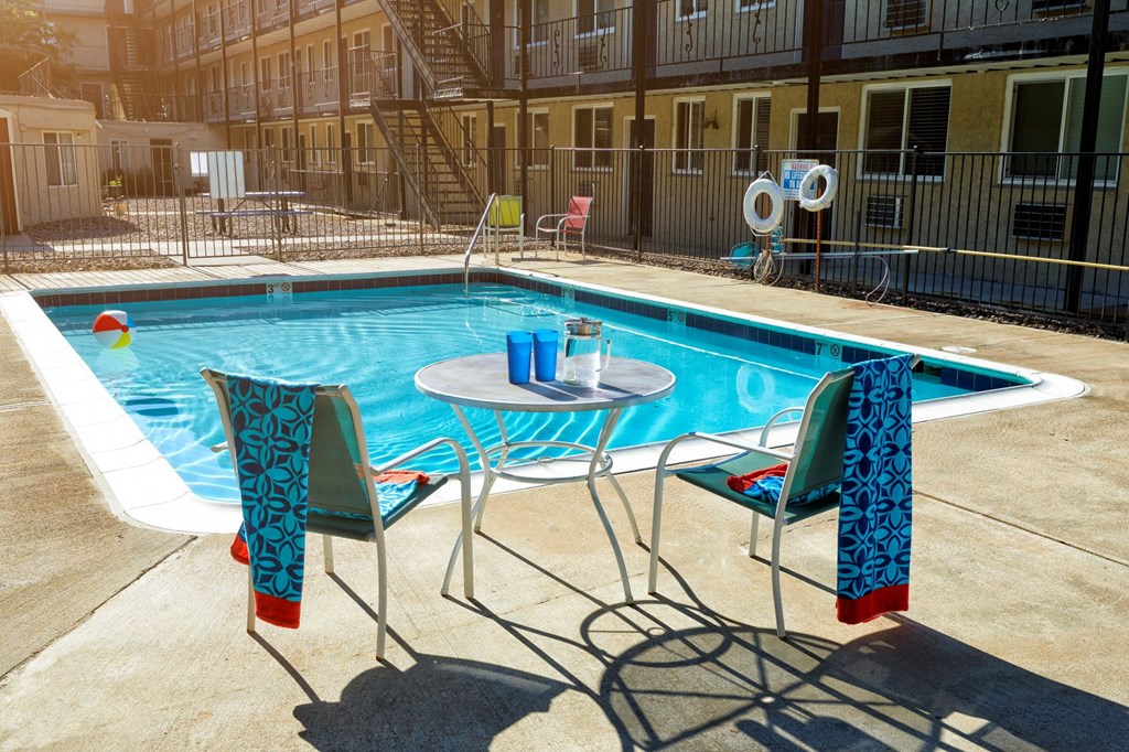 a table and chairs next to a swimming pool