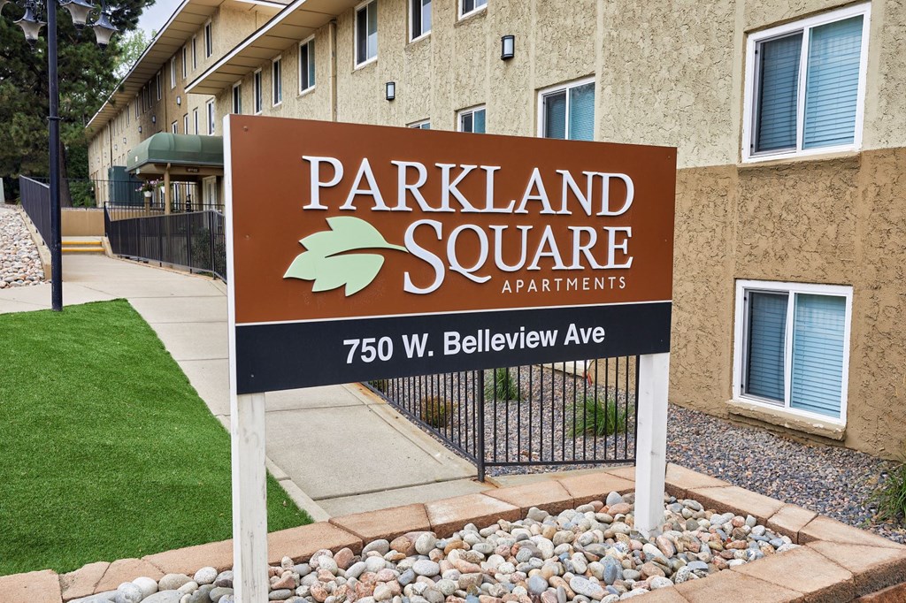 a parkland square apartments sign in front of a building