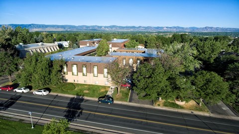 an aerial view of a large building with a highway in the foreground
