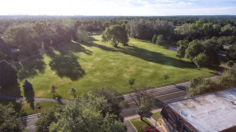 an aerial view of a park with trees and a train track