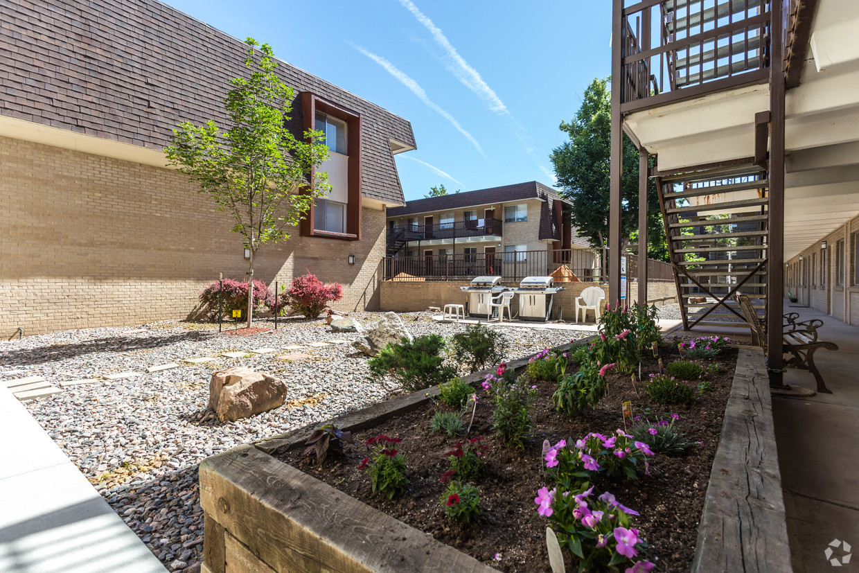 the courtyard of a building with a table and chairs and flowers