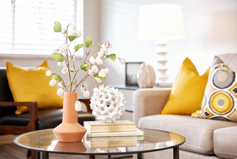 a living room with a couch and a table with flowers