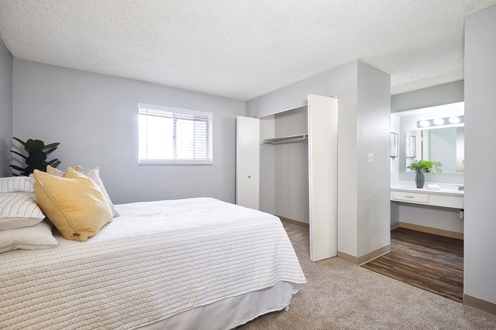 a bedroom with a bed and a bathroom with a sink