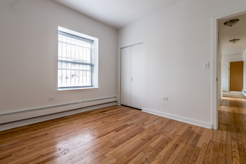a living room with wood floors and a large window