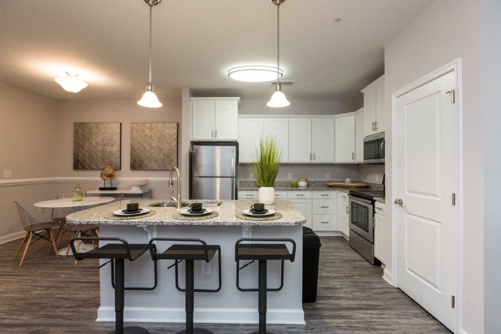 an open kitchen and dining room with a granite counter top