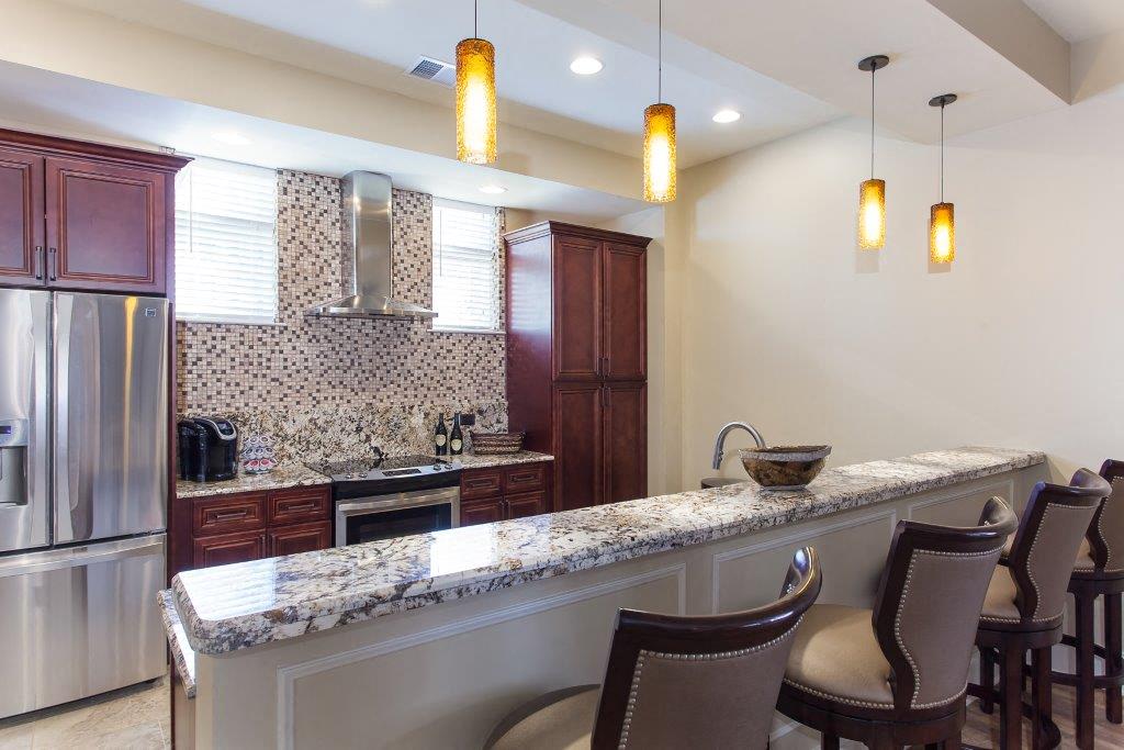 a kitchen with a long counter and chairs