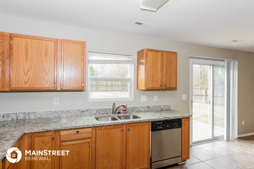a kitchen with wooden cabinets and granite counter tops and a sink