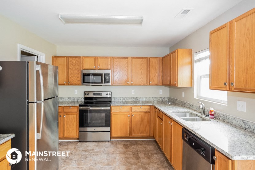 a kitchen with wooden cabinets and stainless steel appliances