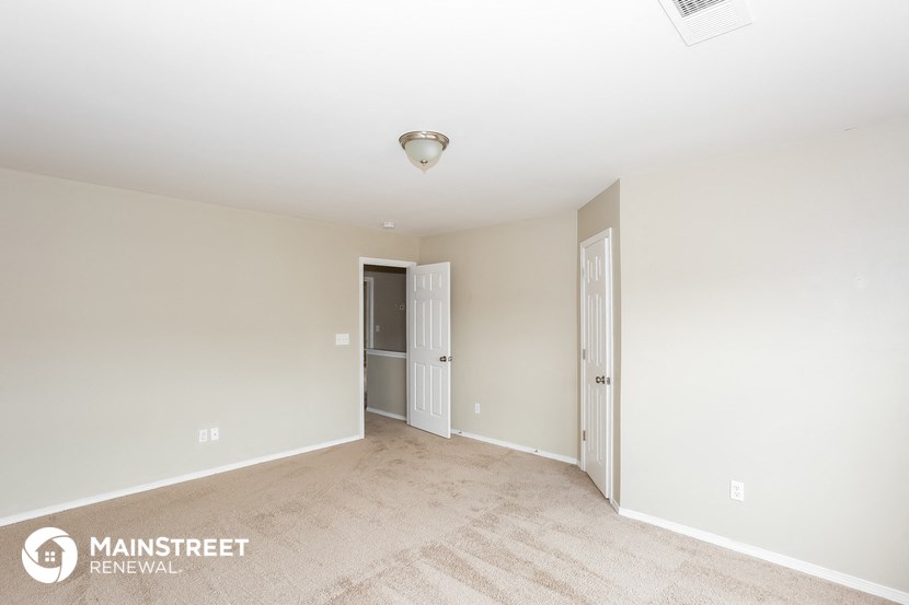 the spacious living room and entryway of an apartment