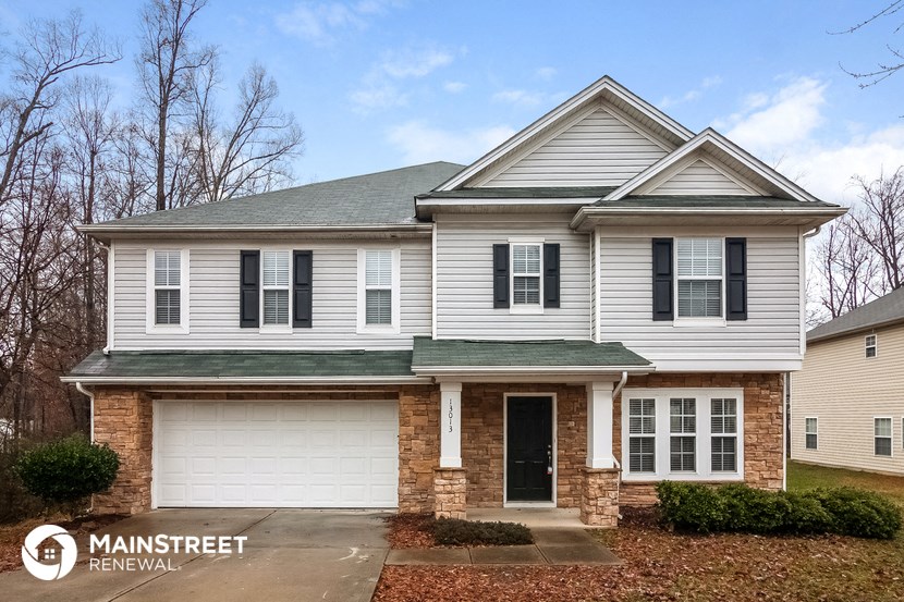 a white house with black shutters and a driveway