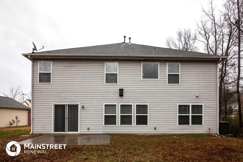 the front of a white house with a gray roof and a garage