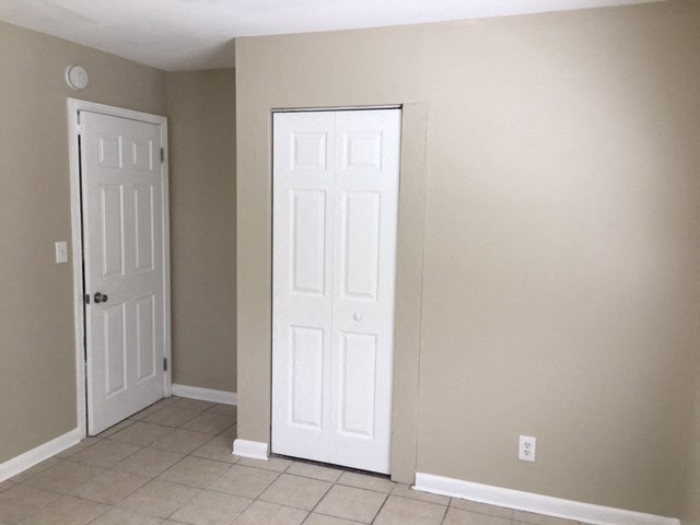 an empty room with two doors and a tiled floor