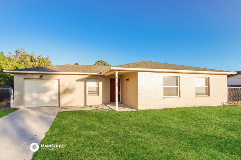 a beige house with a lawn and a garage door