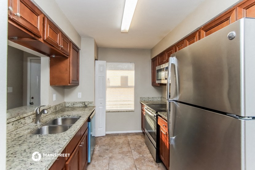 the kitchen has stainless steel appliances and granite counter tops and wood cabinets