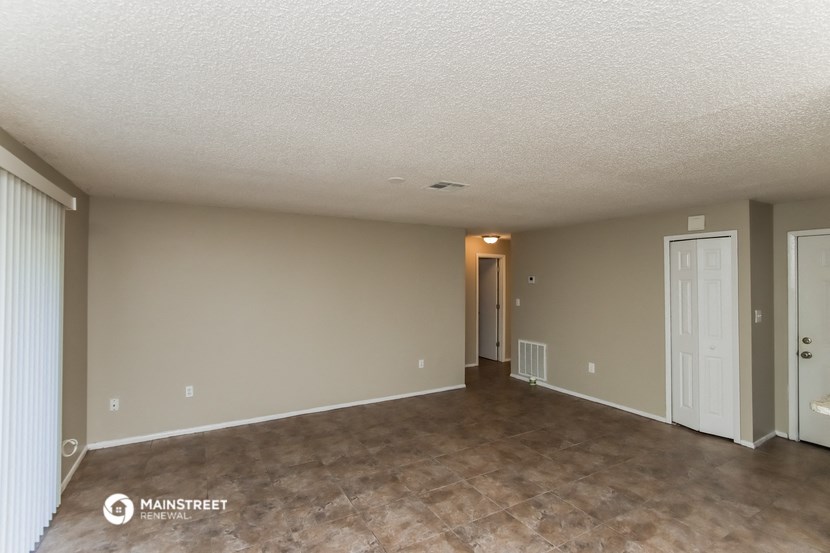 the living room and dining room of an empty house