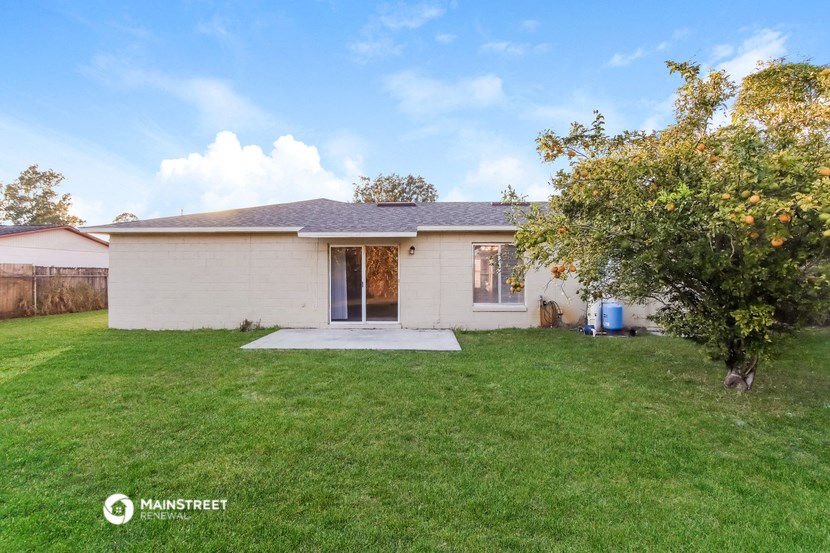 a small white house with a yard and a tree