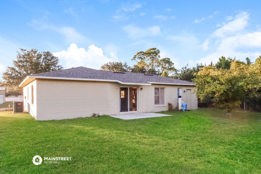 a small white house with a yard and a lawn