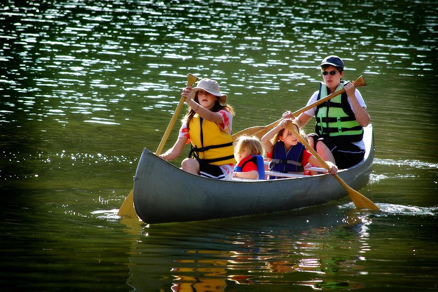 a group of children in a canoe on the water